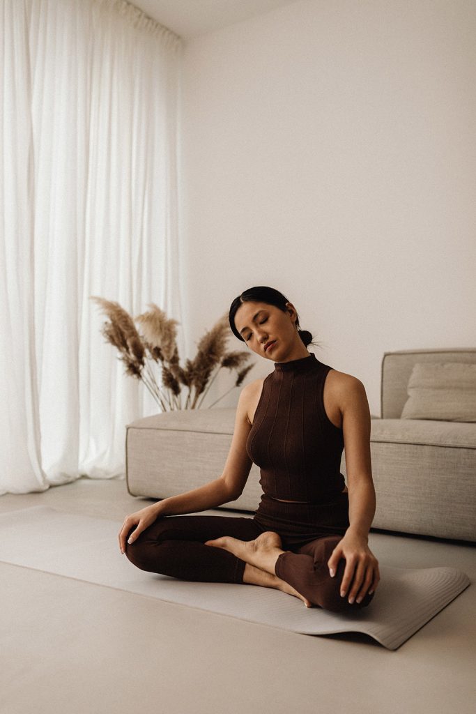 Frau macht Yoga Pilates im Wohnzimmer